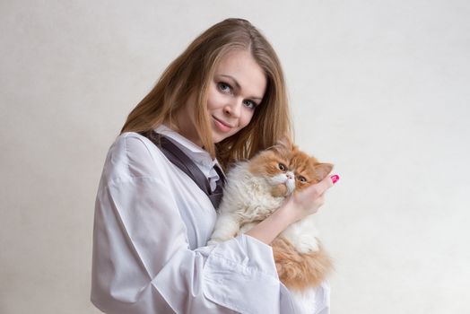 The young nice girl holds a red Persian cat on hands