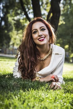 Portrait of young cheerful girl lying on the grass