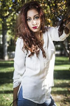 portrait of beautiful young woman in white dress walking in park