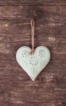 Metal heart on the shabby wooden background