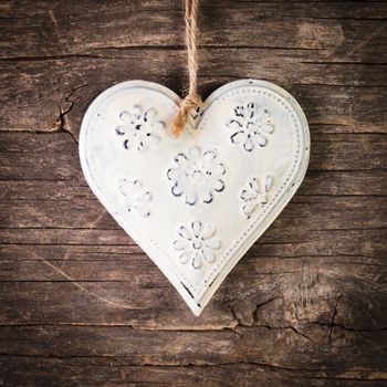 Metal heart on the shabby wooden background