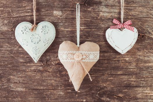 Metal, textile and wooden heart on the old natural background