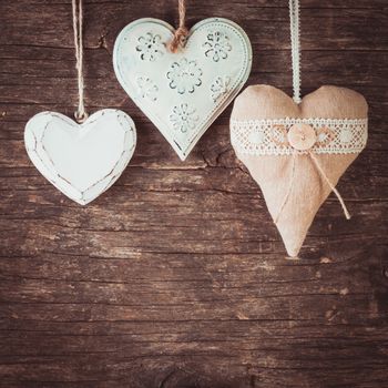 Metal, textile and wooden heart on the old natural background