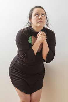 Woman wearing a black dress with wispy flowing hair holding her hand in praying position