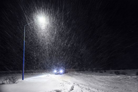 Streetlight and car in the snowstorm at night