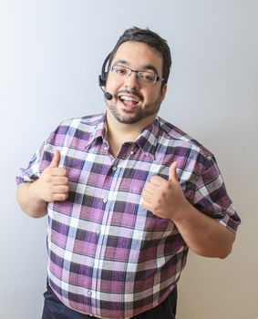 Late twenty year old man with phone headset and his thumb up in sign of approval