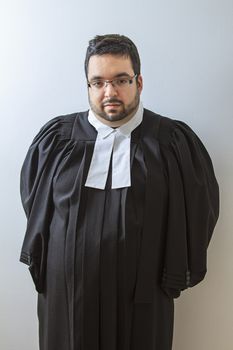 Man wearing a judge toga with hand behind his back