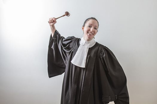 twenty something woman wearing a canadian lawyer toga with a gavel in her hand