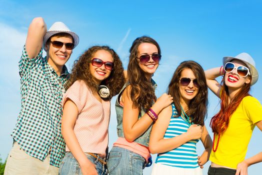 group of young people wearing sunglasses and hats hugging and standing in a row, spending time with friends