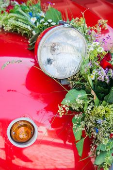 Lamp of a red wedding car with flower bouquet