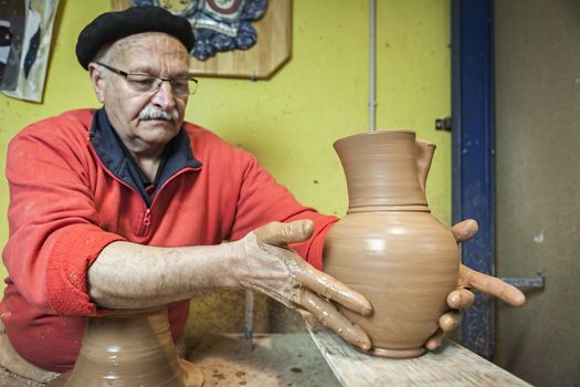 Potter by placing a piece of clay recently made on a wood table, clay pottery ceramics typical of Bailen, Jaen province, Andalucia, Spain