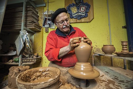 Potter making a water jug in classic mud, clay pottery ceramics typical of Bailen, Jaen province, Andalucia, Spain