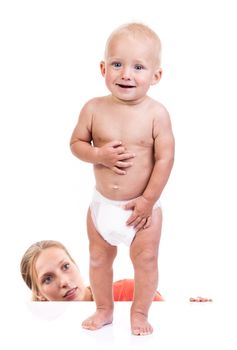 Mother watching her baby boy making first steps over white background