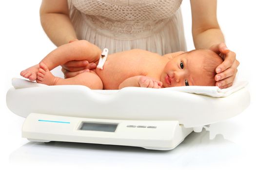 Mother and her newborn baby on a weight scale over white background