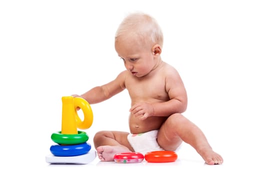 Cute little boy playing with pyramid toy over white background