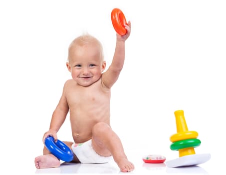 Cute little boy playing with pyramid toy over white background