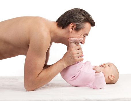 Young Caucasian father leaning over newborn son over white background