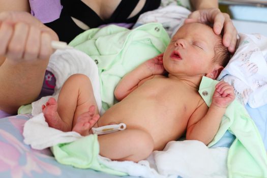 Caucasian woman feeding newborn baby milk with syringe