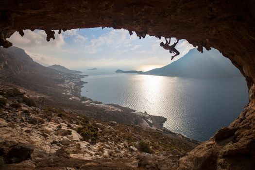 Silhouette of a rock climber against picturesque view of Telendos Island at sunset. Kalymnos Island, Greece.