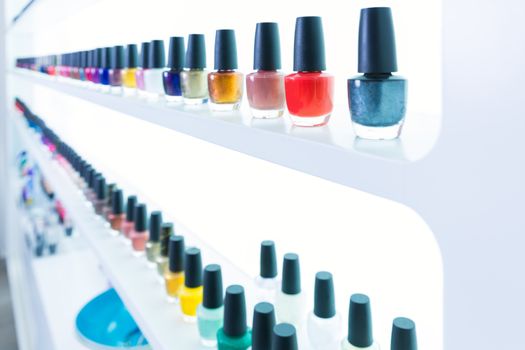 colorful nail polish colors in a row at nails saloon on white background