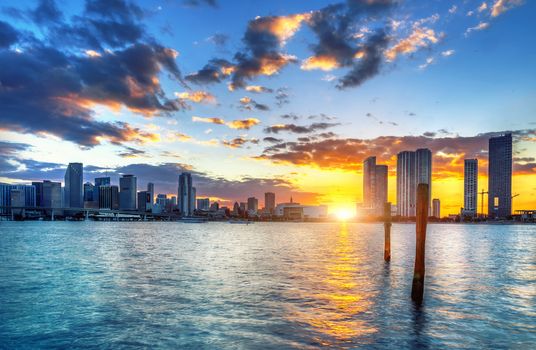 Miami city skyline panorama at dusk with urban skyscrapers over sea with reflection 