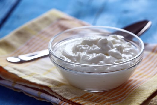 Homemade yogurt in a glass bowl and spoon