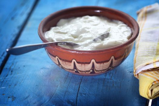 Homemade yogurt in a ceramic bowl and spoon