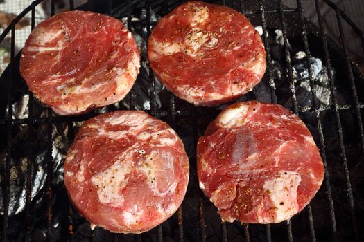 four  pork chops on bbq close up