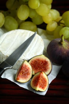 Cheese, knife and figs on a table close up 