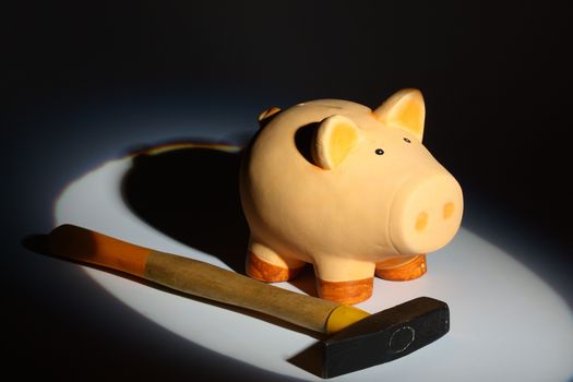 piggy bank and hammer in spot of light