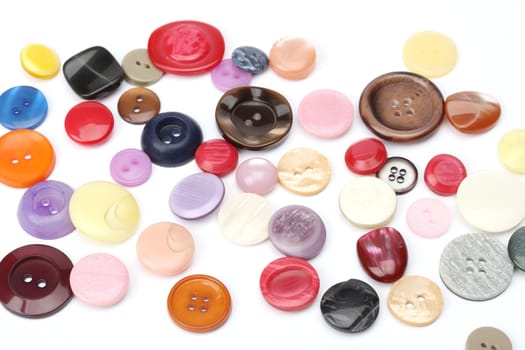 a pile of various colored buttons to sewing