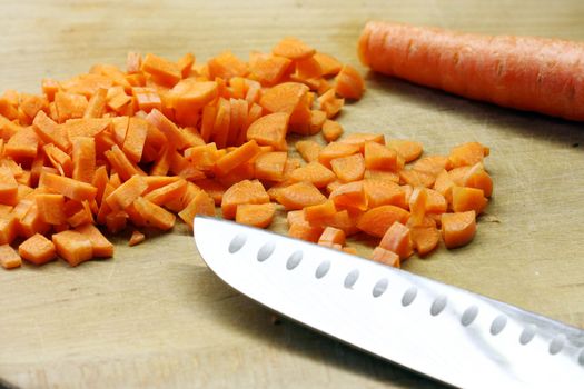 carrots cut  and kitchen knife on wooden plank