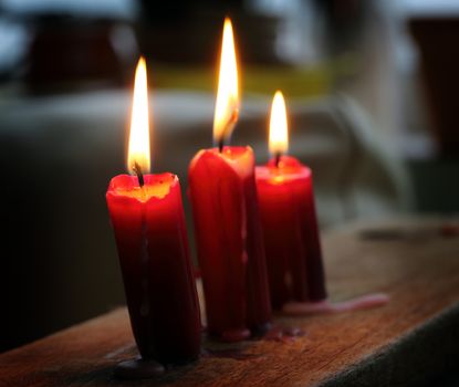 Three glowing candles close up, shallow dof