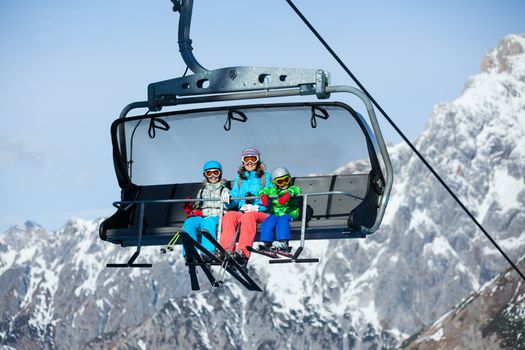 Ski lift, skiing, ski resort - happy family skiers on ski lift