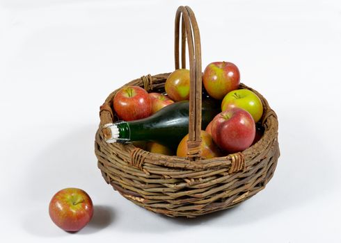 basket of apples with a bottle of Norman cider, isolated on a white background
