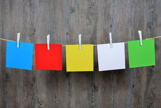 5 colored post it hanging on a clothesline
