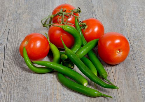 tomatoes and peppers placed on a wooden table
