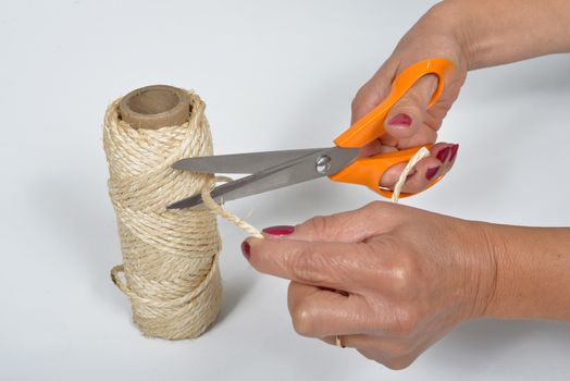 young woman cutting a piece of string
