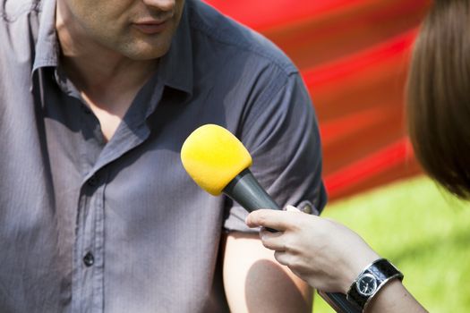 A journalist is making a interview with a microphone