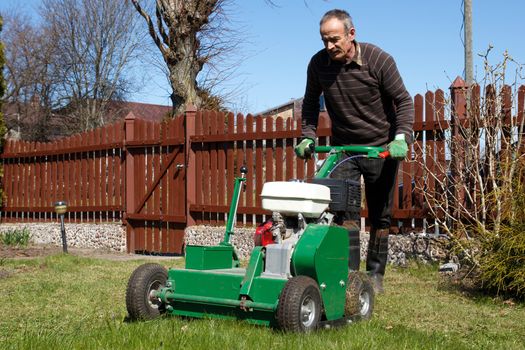 Spring work in garden. Man work with Man working with Lawn Aerator