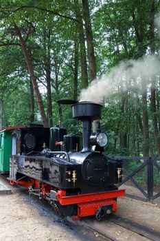 retro small steam locomotive with smoke from the chimney