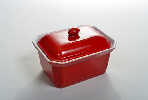 small red porcelain bowl set on a white surface
