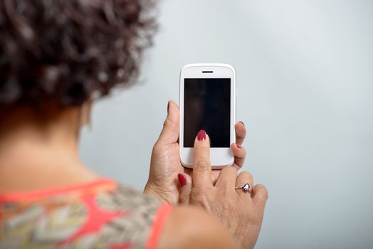 Young woman holding a mobile phone in the hand
