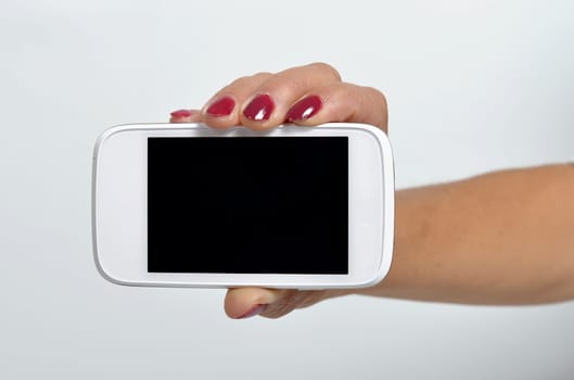 Young woman holding a mobile phone in the hand
