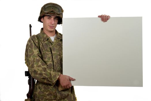 American soldier in camouflage uniform holding a placard