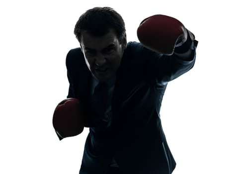 one caucasian businessman with boxing gloves  in silhouette studio isolated on white background