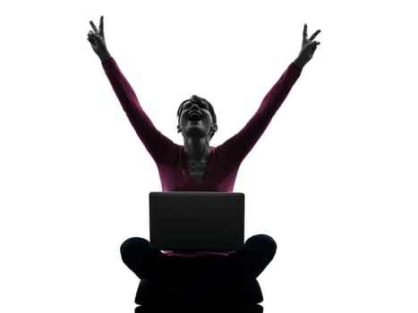 one caucasian woman happy winning computing laptop computer in silhouette studio isolated on white background