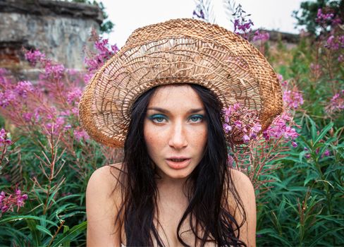 Portrait of a girl against background of nature and old concrete wall