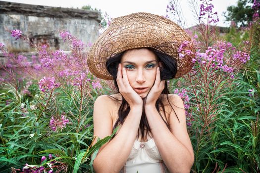 Portrait of a girl against background of nature and old concrete wall