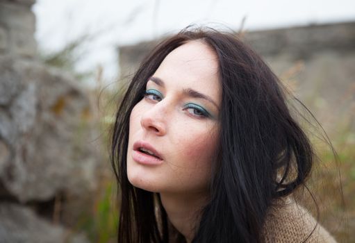 Portrait of a girl against background of nature and old concrete wall